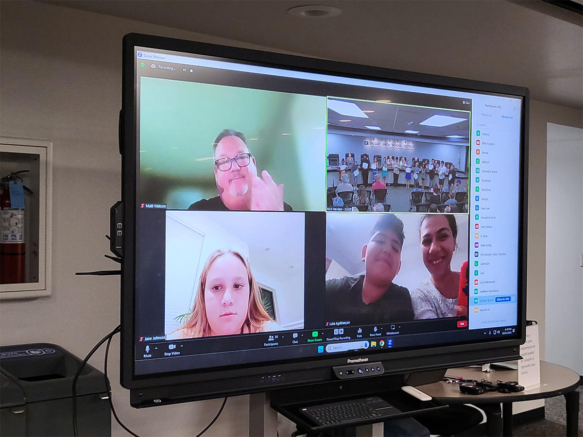 TV screen with people video conferencing in.