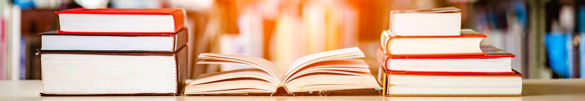 three stacks of books on a desk