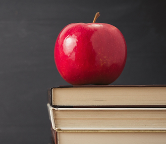 a red apple on a stack of books