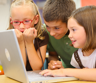 three students working together on a laptop