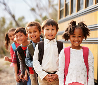 Kids smiling by the bus