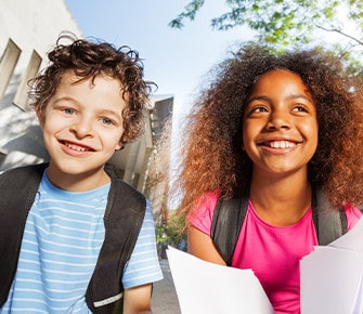 boy and girl with backpacks smiling